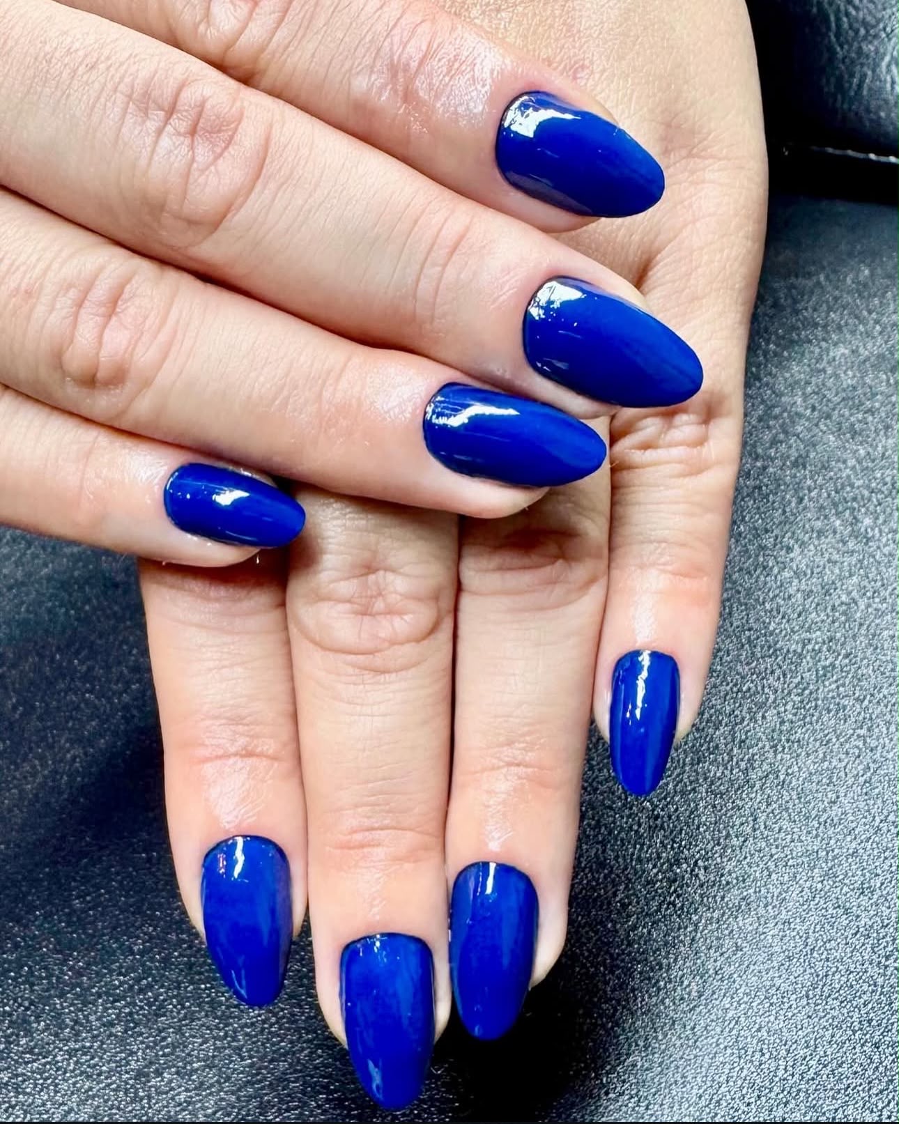Deep royal blue gel polish on almond-shaped nails, glossy finish by STTUDIO BL