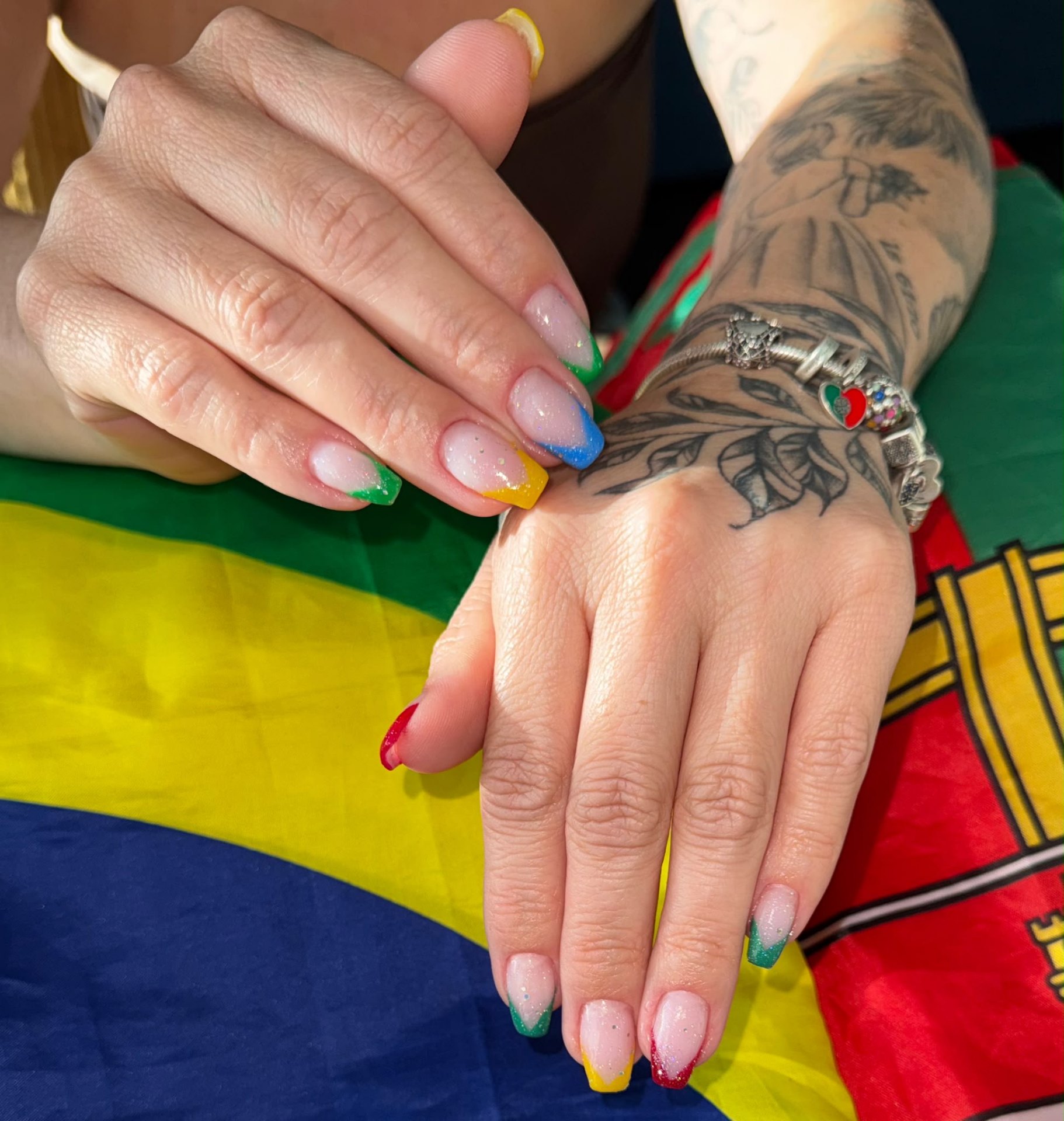 Brazilian-inspired coloured French tips with glitter — green, yellow, blue and red — on square nails by STTUDIO BL